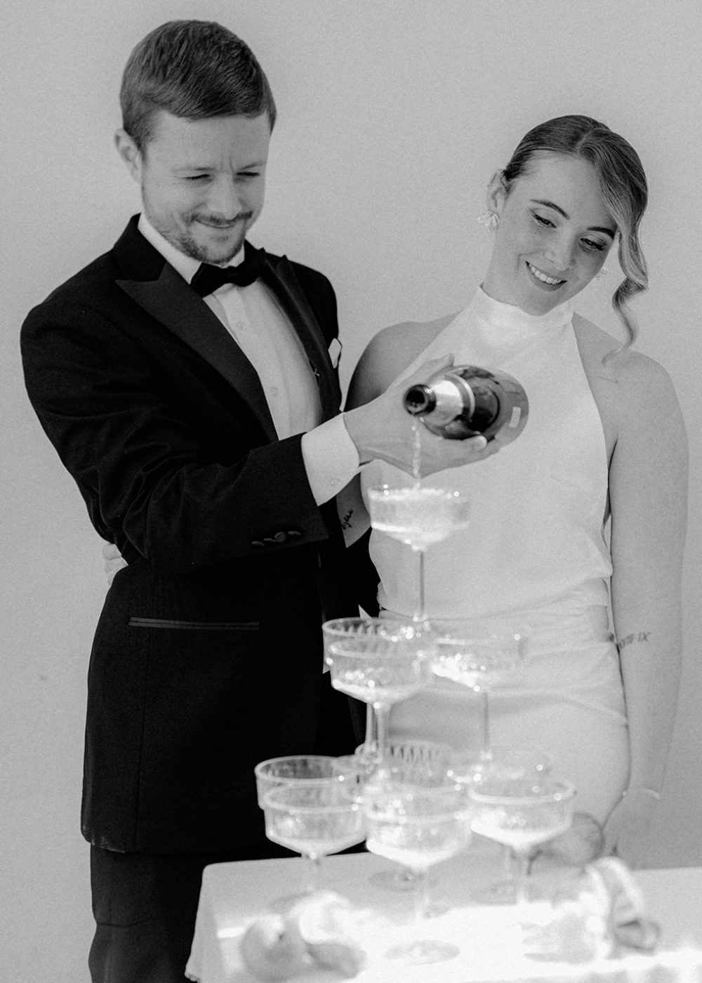 Brautpaar schenkt den Champagner ein. Hochzeit am Bodensee.